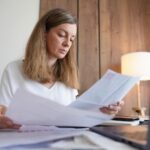 Person reviewing bills at a kitchen table