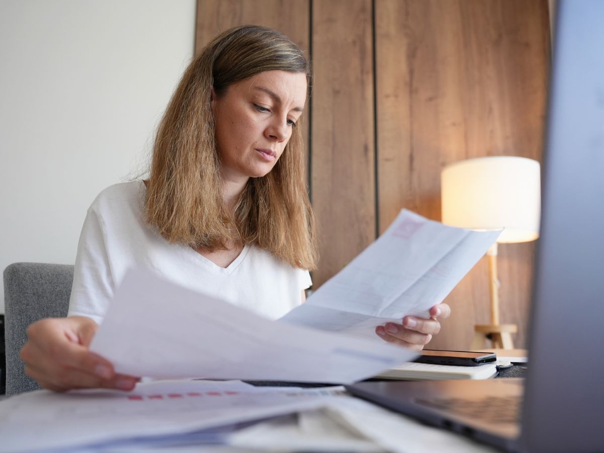 Person reviewing bills at a kitchen table